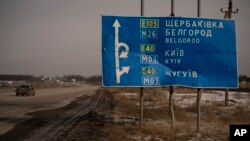 A car drives by a road sign riddled with bullets and shrapnel on the road to Belgorod near Ukraine's border with Russia. (file photo)
