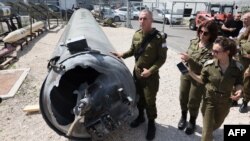 دانیل هاگاری، سخنگوی ارتش اسرائیل، در حال نشان دادن لاشه موشک بالستیک «عماد» ایران که ساقط شده است