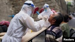 Медицина кызматкери коронавируска текшерүү үчүн анализ алып жаткан учур. Үрүмчү шаары, Шинжаң автоном району, 19-июль, 2020-жыл.  