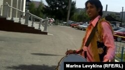 Индийский музыкант из Дели созывает покупателей на ярмарку. Семей, 29 июня 2012 года.   