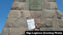 Ақын, азаматтық белсенді Рамиль Ниязов Абай ескерткішінің алдында плакат ұстап тұр. Алматы, 18 шілде 2019 жыл.