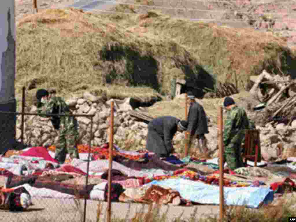 Нұра ауылындағы зілзала құрбандарының мәйіттері, қаза тапқандар аарсында балалар көп.  - YRGYZSTAN, NURA : Kyrgyz rescue workers examine dead bodies at the site of a major earthquake in Nura on October 6, 2008. Rescuers toiled on in a remote mountain village close to Kyrgyzstan's border with China searching for survivors of a powerful earthquake that killed at least 74 people, 41 of them children.