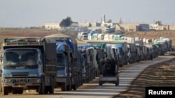 در این تصویر از میانه ژانویه نیروهای «ارتش آزاد» در شمال الباب از کنار کامیون‌هایی که به دلیل شدت درگیری‌ها کنار جاده پارک کرده‌اند، رد می‌شوند.