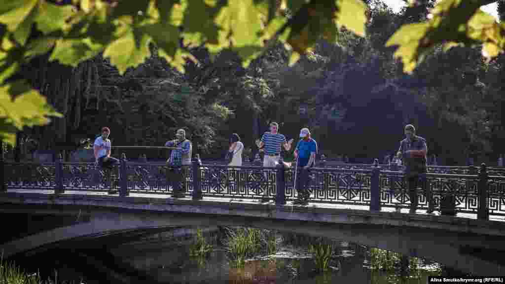 Мужчины рыбачат на мосту. Рыбаки приходят к Салгиру почти каждый день