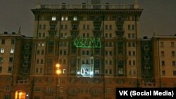 Здание посольства США в Москве, подсвеченное антиамериканской надписью