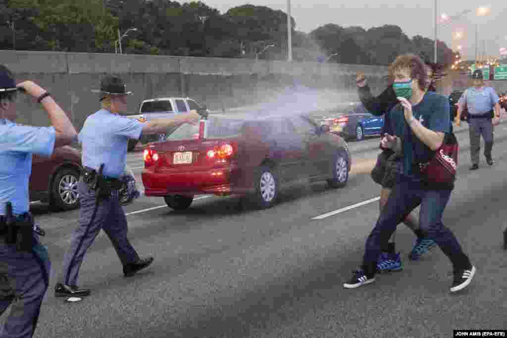 Правоохоронець використовує проти демонстрантів перцевий аерозоль після того, як група протестувальників вийшла на міждержавне шосе після протесту біля ресторану швидкого харчування Wendy&rsquo;s. Атланта, штат Джорджія, США