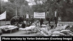 1986 жылғы Желтоқсан оқиғасына қатысқаны үшін қуғын-сүргінге түскендерді ақтауды талап етіп аштық жариялап жатқан белсенділер. Ортада орындықта отырған – Әмина Нұғыманова. Алматы, 14-18 мамыр, 1990 жыл. Қалдыбай Әбеновтің жеке архивіндегі фотоны Азаттыққа ұсынған Ерлан Декелбаев.