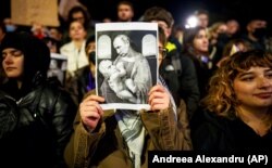 Плакат, на якому зображений керівник Росії Володимир Путін і Келін Джорджеску, який пройшов до другого туру на виборах президента Румунії, на акції протесту в румунській столиці. Бухарест, 25 листопада 2024 року