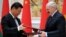 Belarusian President Alyaksandr Lukashenka (right) exchanges documents with Chinese counterpart Xi Jinping during a signing ceremony in Minsk on May 10.