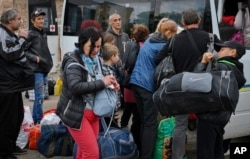 Люди сідають у транспорт під час евакуації з Соледару. Місто було повністю зруйноване в ході бойових дій і з січня 2023 окуповане Росією