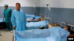 Afghan men who were among the 40 injured in twin suicide bomb blasts receive medical treatment at a local hospital in Kabul on March 1.