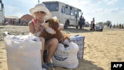 Дівчинка з Донбасу очікує на українсько-російському кордоні відбуття до табору для біженців у Ростов-на-Дону, серпень 2014 року