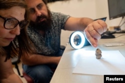 پژوهشگران در حال بررسی پیکرۀ گِلی کشف‌شده