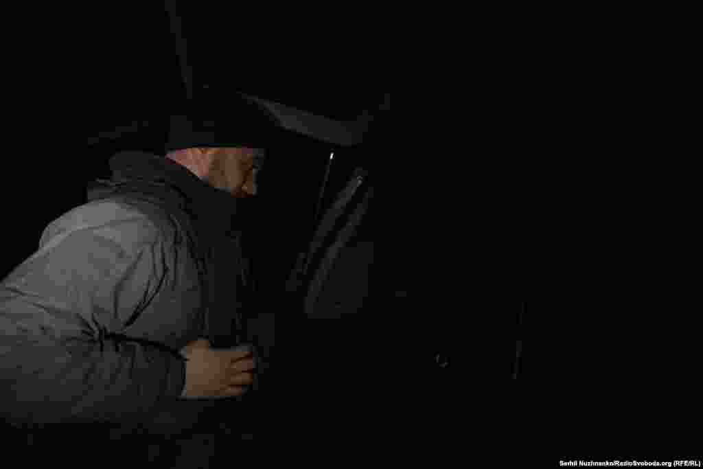 Через добу покидаємо позиції. На цьому ж місці, де минулої ночі одягнули бронежилети, знімаємо їх. Темна пора доби дає більше шансів на безпечний виїзд. На фото: військовий кореспондент Радіо Свобода Марʼян Кушнір знімає бронежилет