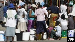 Женщины и дети стоят в очереди за водой в столице Зимбабве. Хараре, 1 декабря 2008 года.  