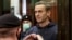 Aleksei Navalny makes a heart symbol from the defendants' cage during a court hearing in Moscow in February 2021.