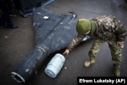 Украинский военный показывает термобарический заряд сбитого ранее беспилотника Shahed, запущенного Россией. 14 ноября 2024 года