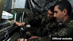 Türkmenistanly kapitan Aly Tuwakgylyjow azerbaýjanly kapitan Samir Akbarly bilen telekommunikasiýa enjamyny öwrenýär, Baumholder, Germaniýa, maý, 2007-nji ýyl.