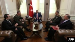 نخست‌وزیر ترکیه در وسط تصویر، دانفور در سمت چپ او و رئیس ستاد متشرک ارتش ترکیه در سمت راست