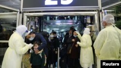 معاینه مسافران چینی با تب‌سنج هنگام ورود به خاک عربستان سعودی