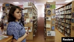 Співробітниця Бібліотеки української літератури стоїть біля книжкових полиць. Москва, 29 жовтня 2015 року