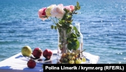 Деңиз жээгиндеги ваза, гүл, мөмөлөр.