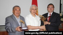 Солдон оңго: Кинематография департаментинин директору Мукталы Бектеналиев, кинорежиссёр Артык Сүйүндүков жана министр Кайрат Иманалиев.