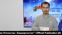 Тимур Пралиев с удостоверением ветерана боевых действий