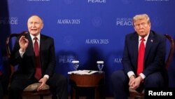 Володимир Путін (ліворуч) реагує на запитання про війну в Україні від іноземних журналістів під час церемонії фотографування з президентом США Дональдом Трампом в Анкориджі, штат Аляска, 15 серпня 2025 року