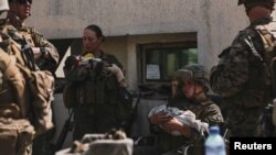 Ամերիկուհի զինծառայողներն օգնում են աֆղանստանցիներին տարհանման ընթացքում, Քաբուլի օդակայան: 