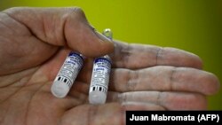 Медработник в Аргентине держит в руках компоненты вакцины «Спутник V». Иллюстративное фото.