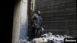 Абу Мохаммад Алая үйүнүн урандыларынын арасында турат.  Чыгыш Гутадагы Доума шаары. 2-март, 2018-жыл.