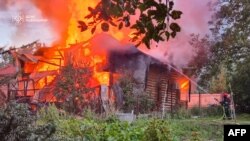 آتش‌نشان اوکراینی در حال مهار آتش پس از حمله هوایی تازۀ روسیه به لِویو