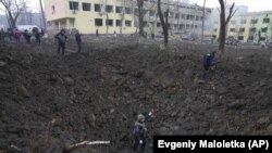 Воронка на месте обстрела возле родильного дома в Мариуполе, 9 марта 2022 года