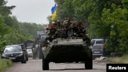 Українські солдати проїжджають місце, де були вбиті 13 українських силовиків, село Волноваха, Донецька область, 22 травня 2014 року