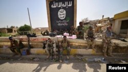 Иракъ -- ШиIатийн Халкъан ницкъийн тIeмалой бу шаьш маьрша яьккхинчу ХIавайа гIалахь хевшина Iаш, "Исламан пачхьалкхо" лелош хилла байракх йиллинчу пенан хьалха. ГIад. 5, 2017 шо