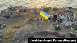 Українські бійці встановлюють національний прапор на острові Зміїний в Чорному морі (Одеська область). Фото опубліковане 7 липня 2022 року. Раніше, після тривалих інтенсивних ударів ЗСУ, російські військові, зазнавши великих втрат, залишили острів