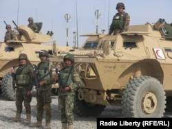 سربازان افغان در کنار تجهیزات آمریکایی هدیه شده به ارتش آمریکا در قندهار در فوریه ۲۰۱۵