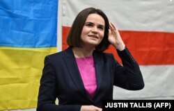 Світлана Тихановська на тлі українського прапора та білоруського національного стягу