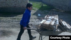 Ученик 4-класса везет в школу тележку с собранным металлоломом. Джизакская область, март, 2015 года.