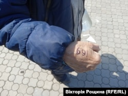 Люди, які стоять в чергах за водою та гуманітарною допомогою пишуть свій номер на руці. Квітень 2022 року