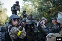 Українські військові несуть пораненого під час бою проти російсько-гібридних сил поблизу міста Іловайська, 10 серпня 2014 року