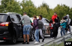 گروهی از پناهجویان در تلاش برای گرفتن تاکسی که آنها را از مجارستان به وین در اتریش برساند