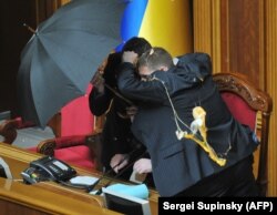 Володимира Литвина, голову Верховної Ради, прикривають парасольками під час голосування за «Харківські угоди»