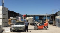 Грузчик укладывает мешки на багажник старой «Волги» водителя Ерлана.