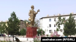 Türkmen dutaryny göterýän adamyň heýkeli. Illýustrasiýa suraty