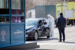 Молдовські прикордонники вимірюють температуру водіїв та пасажирів на кордоні Молдови. 14 березня 2020 року