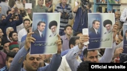 دو تن از هواداران محمود احمدی‌نژاد پلاکاردهایی در دست دارند که روی آن نوشته شده است: «دکتر، آقا تنهاست».