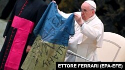 Папа Римський Франциск тримає прапор, який йому привезли з Бучі