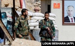 نیروهای دولتی سوریه در مارس ۲۰۱۸ در غوطه/ تصاویر پوتین و اسد در پس‌زمینه دیده می‌شود